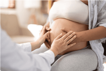 zwangere buik met zorgverlener